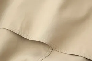 Close-up van kaki trenchcoat stof met gedetailleerde dubbele naad
