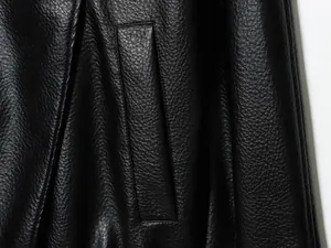 Detailaufnahme der Narbenleder-Textur und Tasche an einer schwarzen Kunstlederjacke.