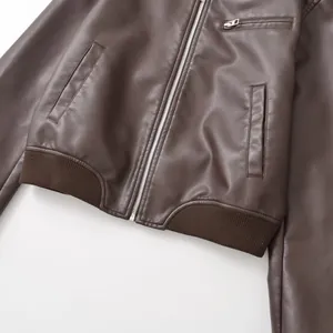 Close-up detail of retro brown faux leather bomber jacket with ribbed hem and zipper