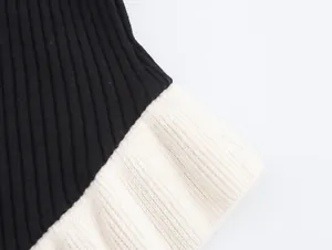 Detailed macro shot of the ribbed knit fabric on a black and cream long-sleeve sweater