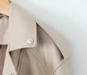 Détail d'une veste de motard en similicuir beige montrant le col et les boutons