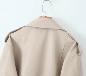 Vue détaillée du dos d'une veste de motard beige en simili cuir suspendue à un cintre bois.