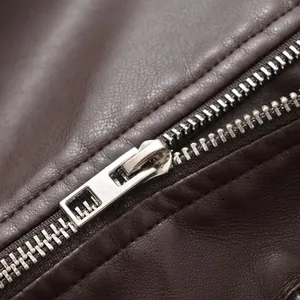 Close-up showing smooth metal zipper and textured brown faux leather on moto jacket