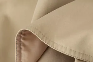 Macroweergave van hoogwaardige stiksels en stoftextuur van een kaki trenchcoat
