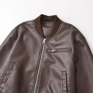 Detail view of brown vintage faux leather bomber jacket featuring ribbed collar and zippers