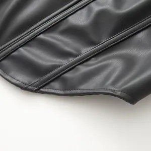 Gedetailleerde macro-opname van zwart PU-leren jasje met visgraatnaden en textuur