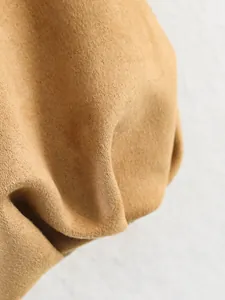Macro detail of the soft khaki suede fabric texture on a casual stylish women's jacket