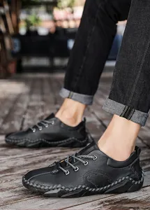 Détail de chaussures décontractées en cuir noir pour hommes avec lacets gris et coutures