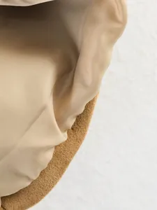 Detailed macro view of khaki suede jacket lining with smooth beige satin texture