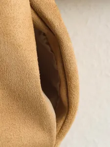 Macro detail of the pocket and suede fabric texture on khaki women's casual coat