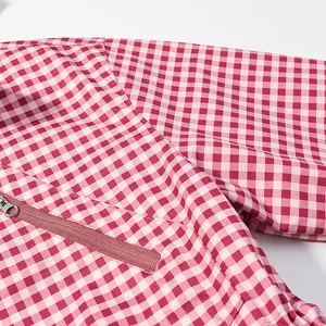 Close-up of pink checkered jacket showing zipper detail and high-quality fabric texture