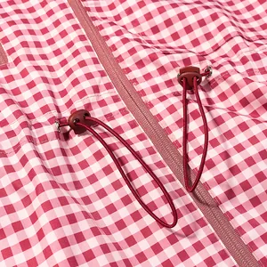 Macro view of red and white gingham jacket featuring drawstring and toggle detail