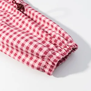 Detail view of the elasticated cuff on red and white gingham plaid windproof jacket