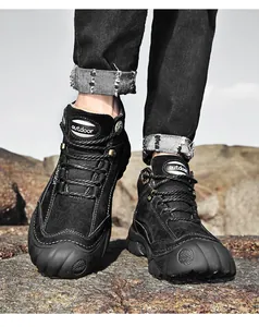 Close-up van zwarte hoge outdoor wandelschoenen voor heren met veters op rotsachtige grond.