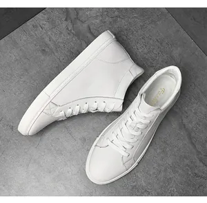 Dettaglio macro di sneaker in pelle bianca premium con cuciture eleganti e suola piatta.