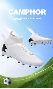 Botas de fútbol blancas de caña alta con detalles negros y tacos sobre césped