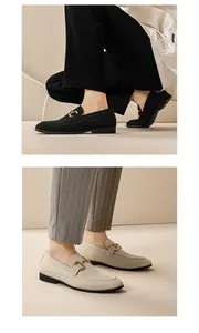 Detailed side view of men's suede loafers in black and beige with elegant gold buckle