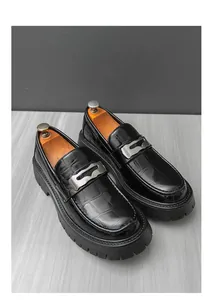 Vue rapprochée de mocassins noirs haut de gamme avec motif crocodile et semelle épaisse