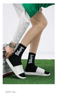 Vue latérale détaillée de claquettes blanches minimalistes à semelles souples sur l'herbe