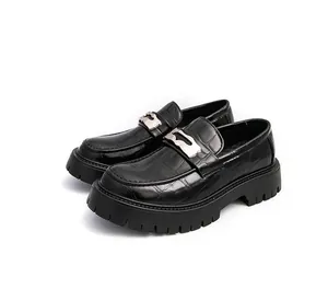 Vue détaillée de mocassins noirs à semelle plateforme avec motif crocodile et boucle métal.