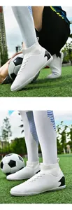 Primer plano detallado de botas de fútbol blancas para hombre con tacos sobre césped