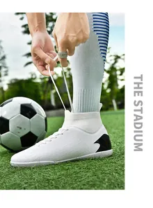 Detalle de botas de fútbol de caña alta blancas con cordones atados en un campo verde