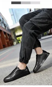 Κοντινό πλάνο σε μαύρα ανδρικά δερμάτινα sneakers που φοριούνται με μαύρο τζιν