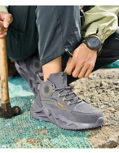 Zapatillas de seguridad grises para hombre con suela gruesa antipinchazos en uso.