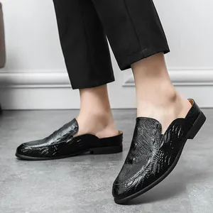 Eleganti sabot da uomo in pelle nera con motivo a coccodrillo e design alla moda.