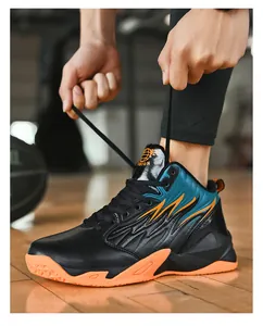 Detalle lateral de zapatillas de baloncesto de cuero de caña alta para hombre con suelas naranjas