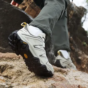 Men's outdoor low-top hiking shoes with chunky anti-slip soles on rugged rocks