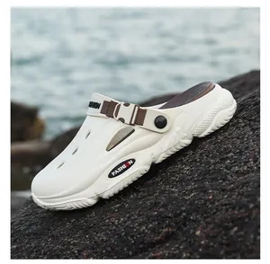 Detailed view of white men's outdoor clogs with buckle strap on a rock background