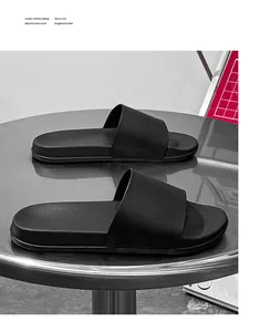 Paire de claquettes noires minimalistes à semelle souple posées sur une table en métal