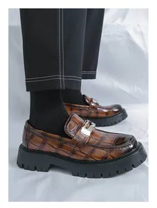 Gros plan de mocassins marrons à motif crocodile avec semelles compensées