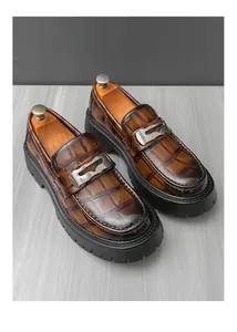 Gros plan de mocassins marrons pour hommes avec texture crocodile et semelle épaisse