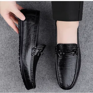 Detail view of premium black leather men's slip-on loafers with chic metallic buckle