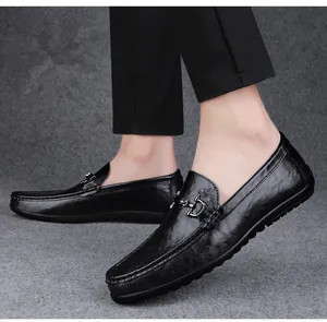 Close-up of men's black leather loafers with metal buckle in a business casual style