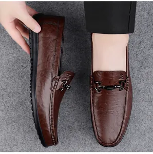 Detailed view of brown leather loafers with elegant metal bit buckle and textured finish