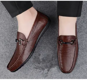 Close-up of brown textured leather loafers with black metal buckle and soft rubber sole