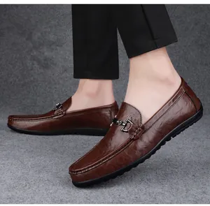 Close-up of brown leather slip-on driving shoes with elegant metal buckle detail.