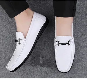 Detailed view of white men's leather slip-on loafers featuring a metal horsebit buckle