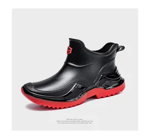 Side view of waterproof short rain boots with red thick soles and anti-slip tread