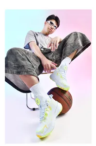 Detailed view of men's mid-top basketball shoes with neon yellow accents and thick sole