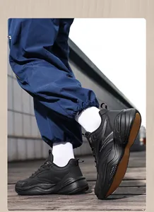 Detail view of men's black thick-soled sneakers worn with blue cargo pants