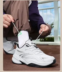 Close-up of white chunky leather sneakers being laced up in an outdoor setting
