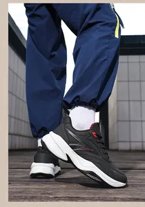 Close-up of trendy black leather sports shoes with thick white soles on outdoor deck