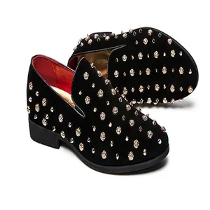 Detail van stijlvolle zwarte herenloafers met gouden studs en gedetailleerde rozen.