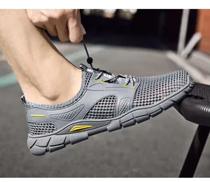 Detailopname van grijze ademende mesh-instapsneaker voor heren met felle gele accenten