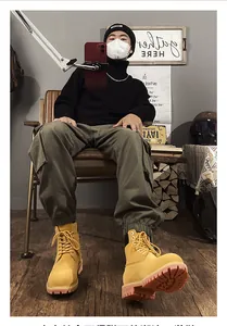 Botas de trabajo amarillas clásicas con pantalones cargo verdes en un ambiente acogedor.