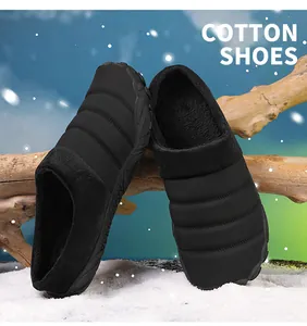 Detailed view of black quilted fleece-lined winter cotton slippers on snowy wood background
